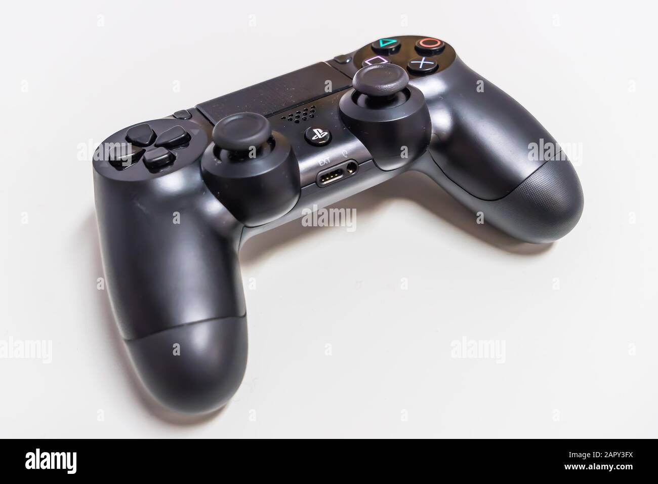 Manette de jeu PlayStation 4 sur une table blanche Banque D'Images