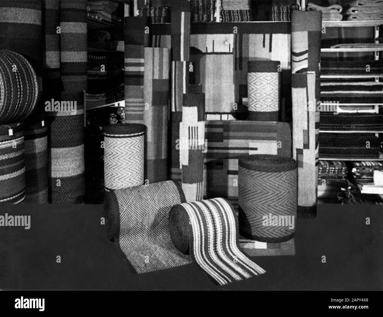 Rouleaux de tapis et de marches d'escalier (avec motifs Art déco), présentés dans un magasin. Aux fins d'un montage de texte ou de photo [publicité], le dessous est retouché par la peinture corporelle. Lieu et date inconnus [probablement les Pays-Bas, années 1930]. Banque D'Images
