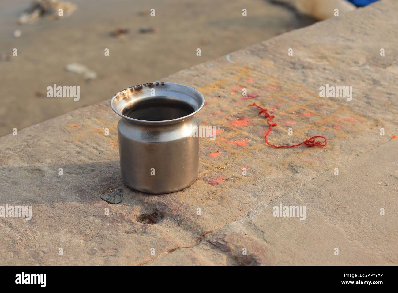 Un mug en acier inoxydable au sol près de la rivière Ganges Banque D'Images