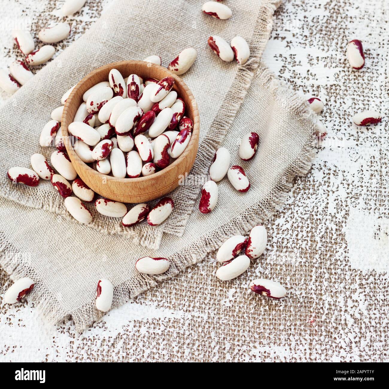 haricots blancs-roses dans une tasse en bois sur fond clair. Banque D'Images