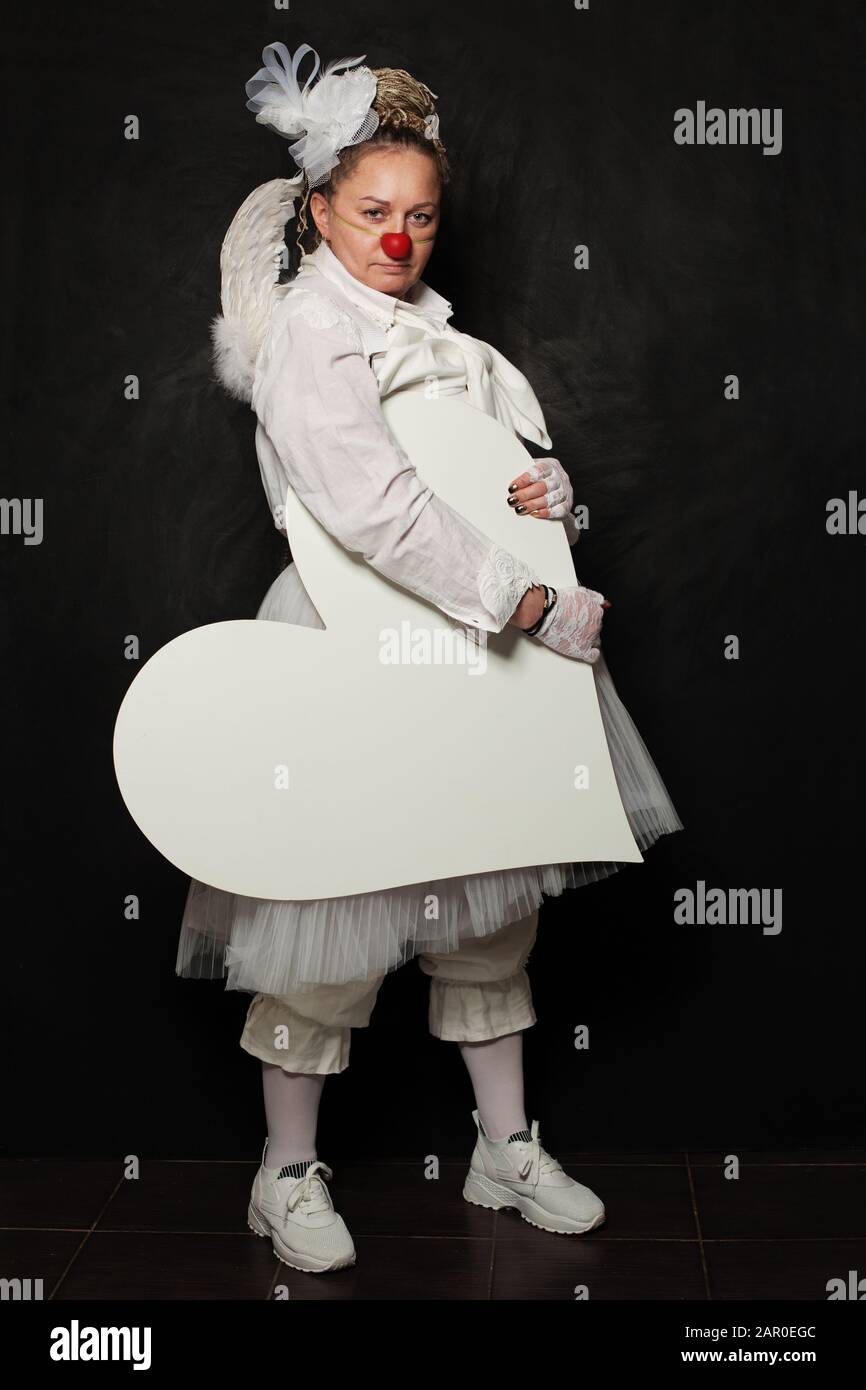 Femme clown blanche avec bannière de coeur vide blanche sur fond noir Banque D'Images
