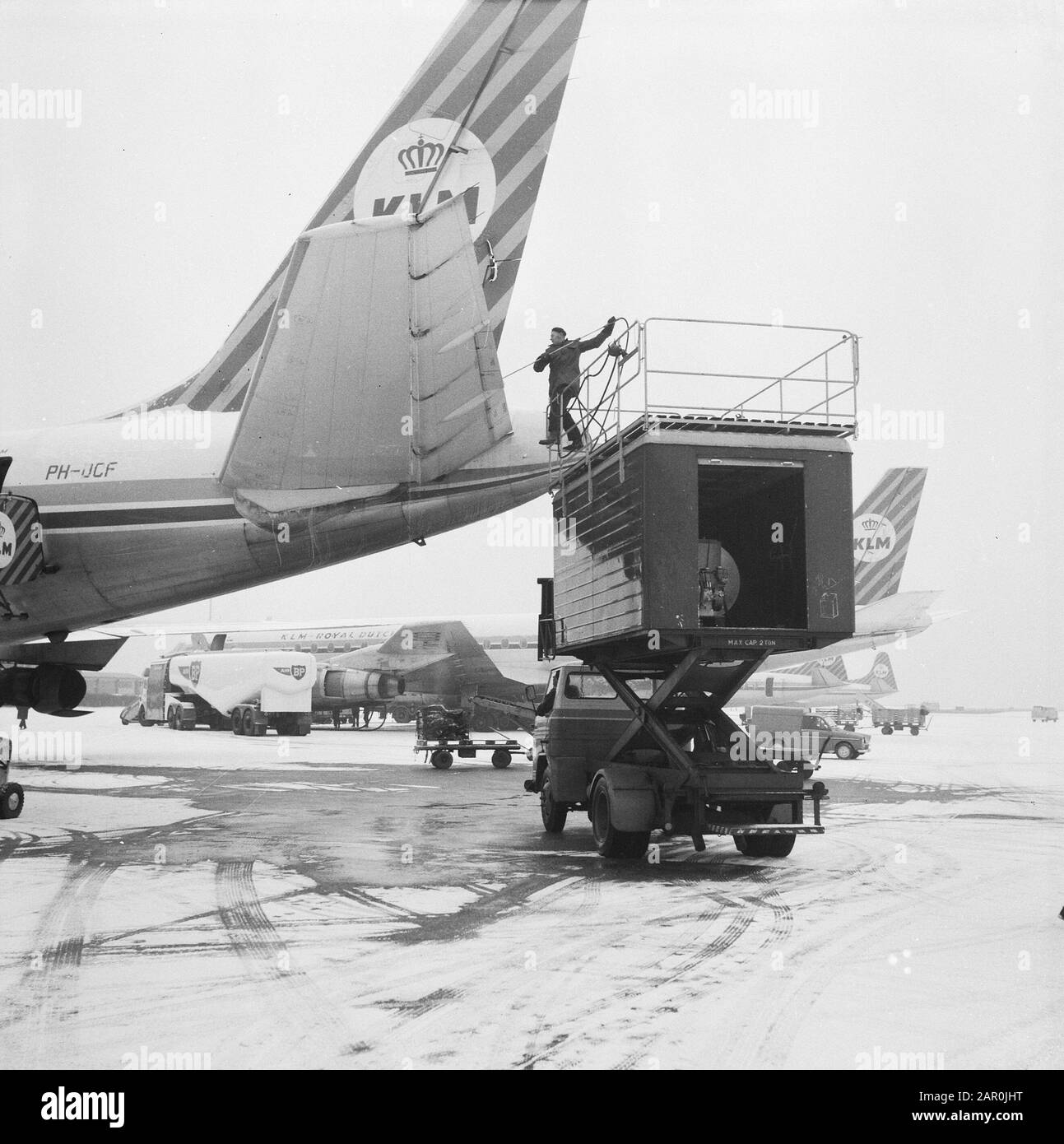 Une nouvelle défense contre les dépôts de glace est pulvérisée contre et sur les surfaces de frein d'aile et les surfaces de barre des aéronefs à Schiphol Date : 13 janvier 1964 lieu : Noord-Holland, Schiphol mots clés : avions, glace Banque D'Images