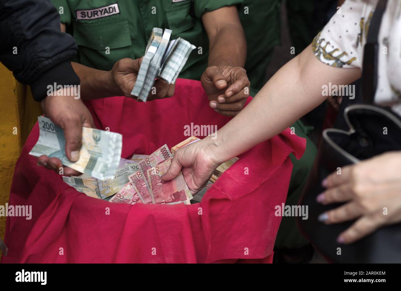 Les mains des gens distribuent de l'argent lors de la célébration du nouvel an chinois à Jakarta. Banque D'Images