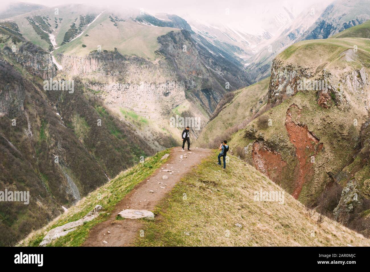 Mtiuleti Region, Géorgie - 21 Mai 2016: Deux Touristes Sont Photographiés Sur Le Bord De La Gorge De Gudskoye En Géorgie, Région De Mtiuleti. Terre De Montagne De Printemps Banque D'Images