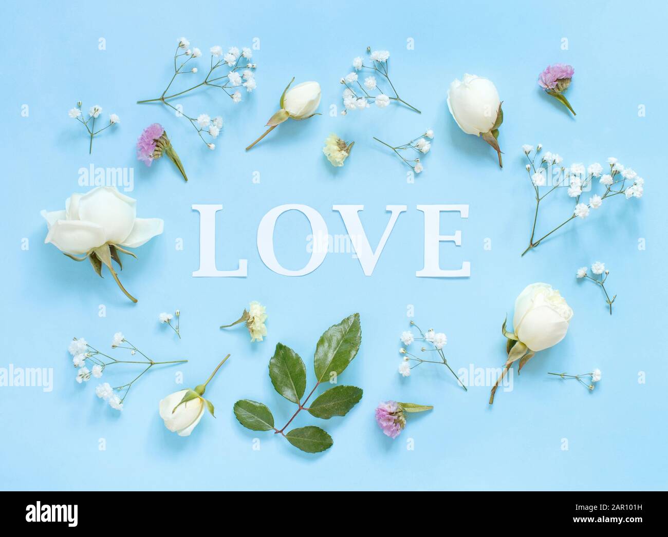 Fleurs et mot amour sur un fond bleu clair vue supérieure Banque D'Images