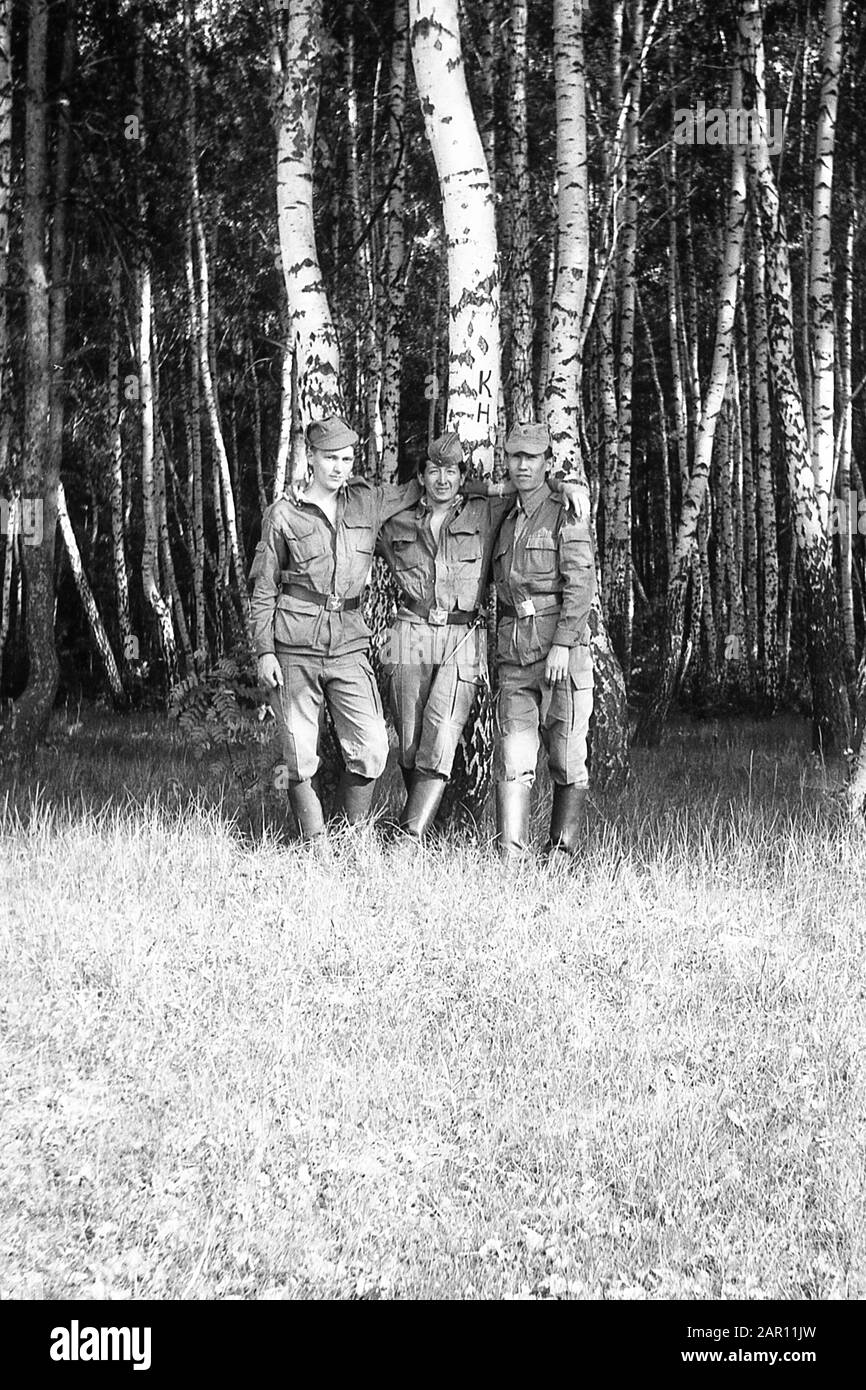 STUPINO, RÉGION DE MOSCOU, RUSSIE - VERS 1992: Portrait de trois camarades, soldats de l'armée russe dans une bosquet de bouleau. Noir et blanc. Numérisation de film. Gros grain. Banque D'Images
