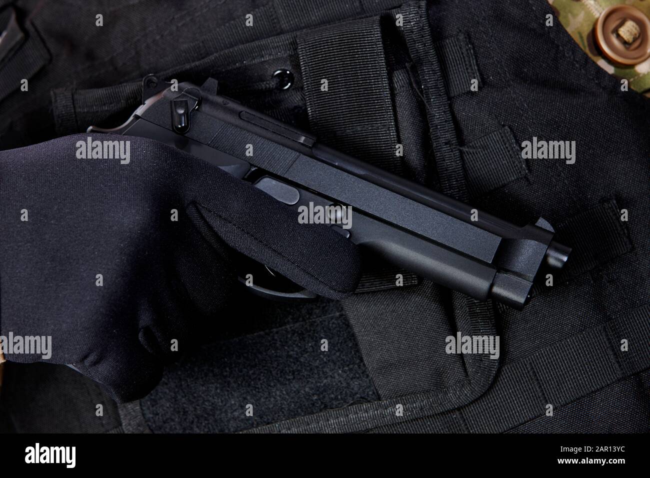 homme portant une veste résistante aux balles avec une main gantée tenant beretta pistolet semi-automatique, milice militaire concept de sécurité privée entrepreneur arme armée Banque D'Images