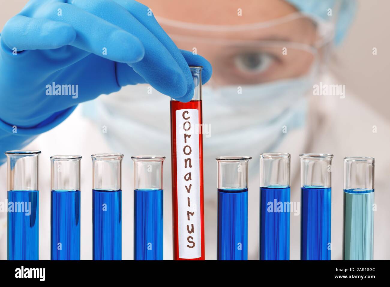 Dans un laboratoire de chimie, une chercheuse féminine possède un tube à essai avec le virus du coronavirus. Analyse, protection et médicaments pour lutter contre l'épidémie. Banque D'Images