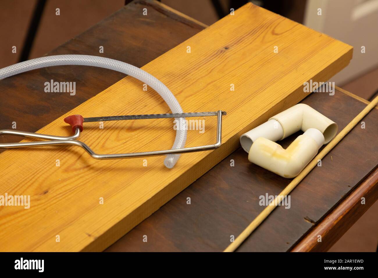 Une scie à hack junior est utilisée pour couper un petit morceau de tubulure en plastique Banque D'Images