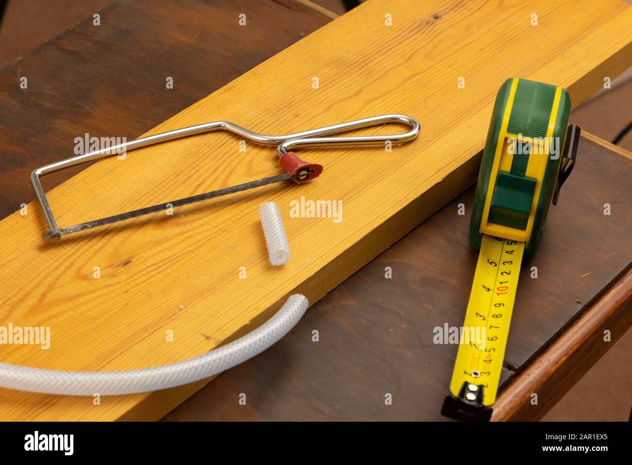 Une scie à hack junior est utilisée pour couper un petit morceau de tubulure en plastique Banque D'Images