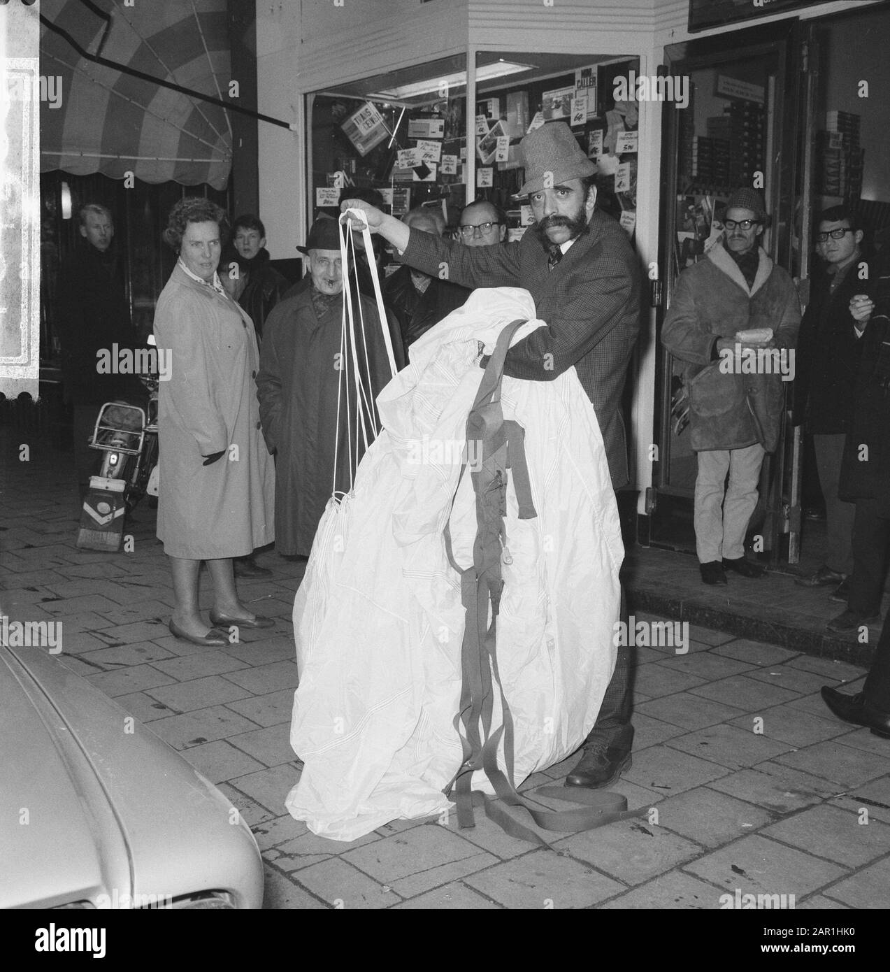 Hein Fentener van Vlissingen lors de l'achat d'un parachute chez Lou Lou Lap à Amsterdam Hein Fentener van Vlissingen avec le parachute dans ses bras, entouré de passants curieux : 11 novembre 1965 lieu : Amsterdam, Noord-Holland mots clés : parachutistes, public, boutiques Nom personnel : Fentener van Vlissingen, Lou, Lou, Lou Banque D'Images