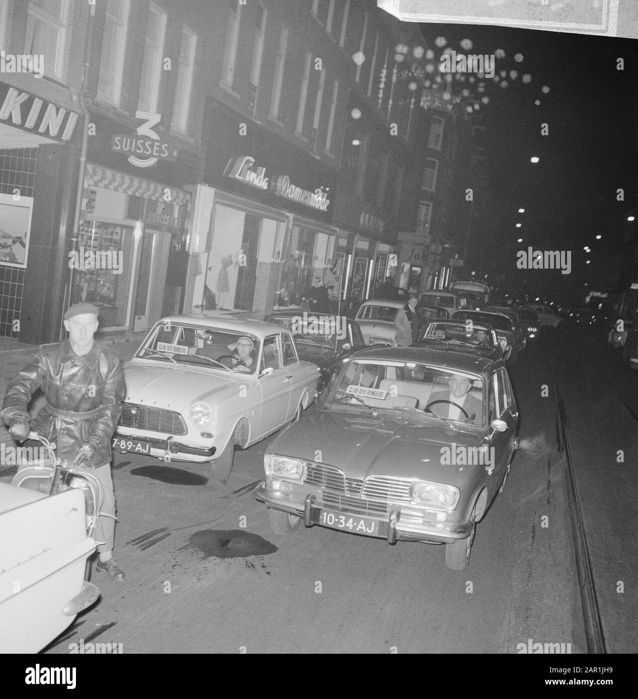 Association Club der Cent (poisson); embouteillage de voitures dans la soirée dans une rue commerçante Date: 16 décembre 1965 mots clés: Voitures, soir, circulation, Banque D'Images