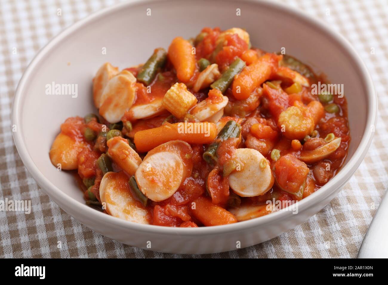 Saucisse de poulet et ragoût de légumes avec carottes, maïs, haricots verts, poivre, pois verts et sauce tomate Banque D'Images