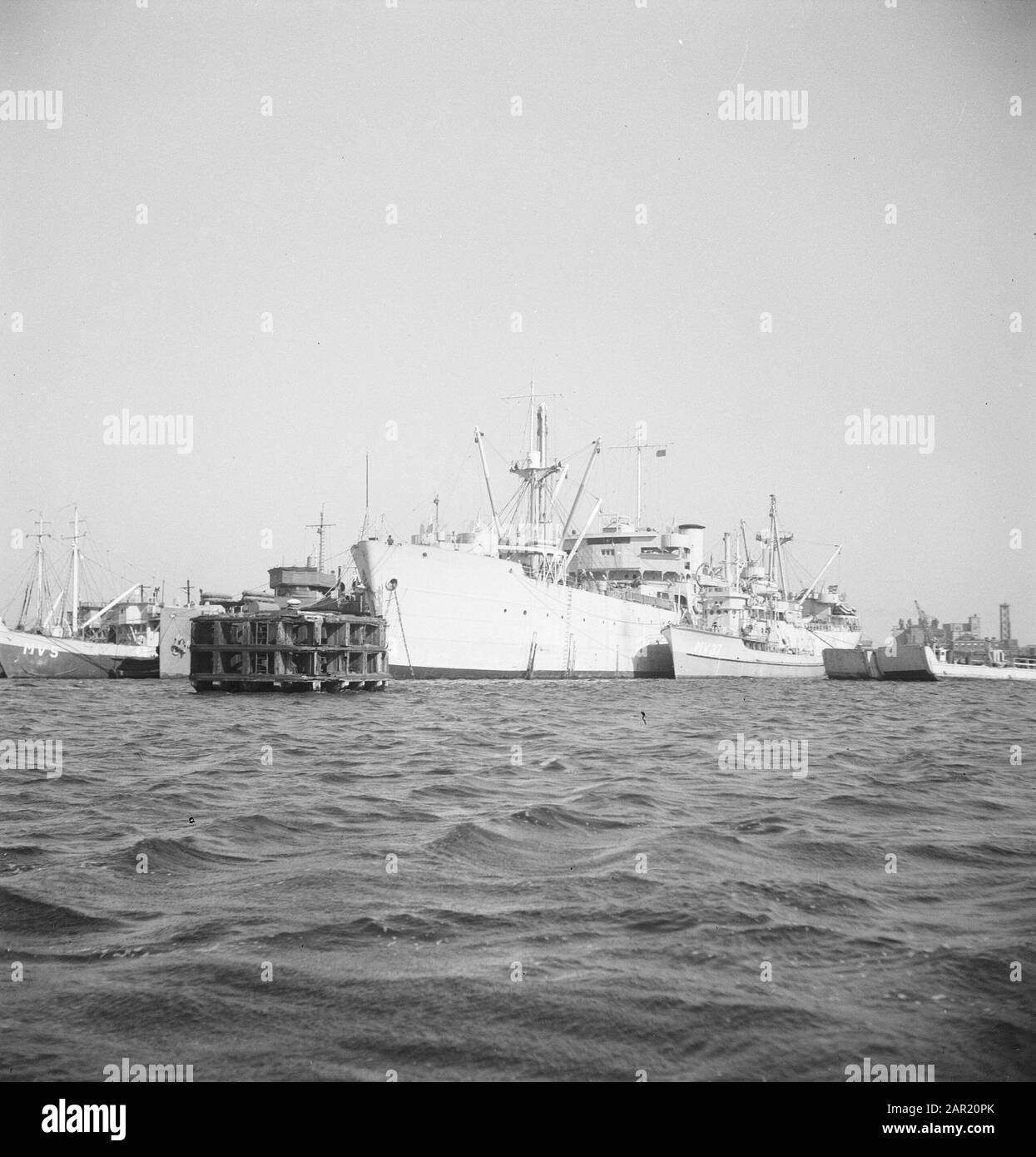 Cargo flanqué de navires de guerre et de navires d'atterrissage au port Date: 19 septembre 1947 mots clés: Navires Banque D'Images