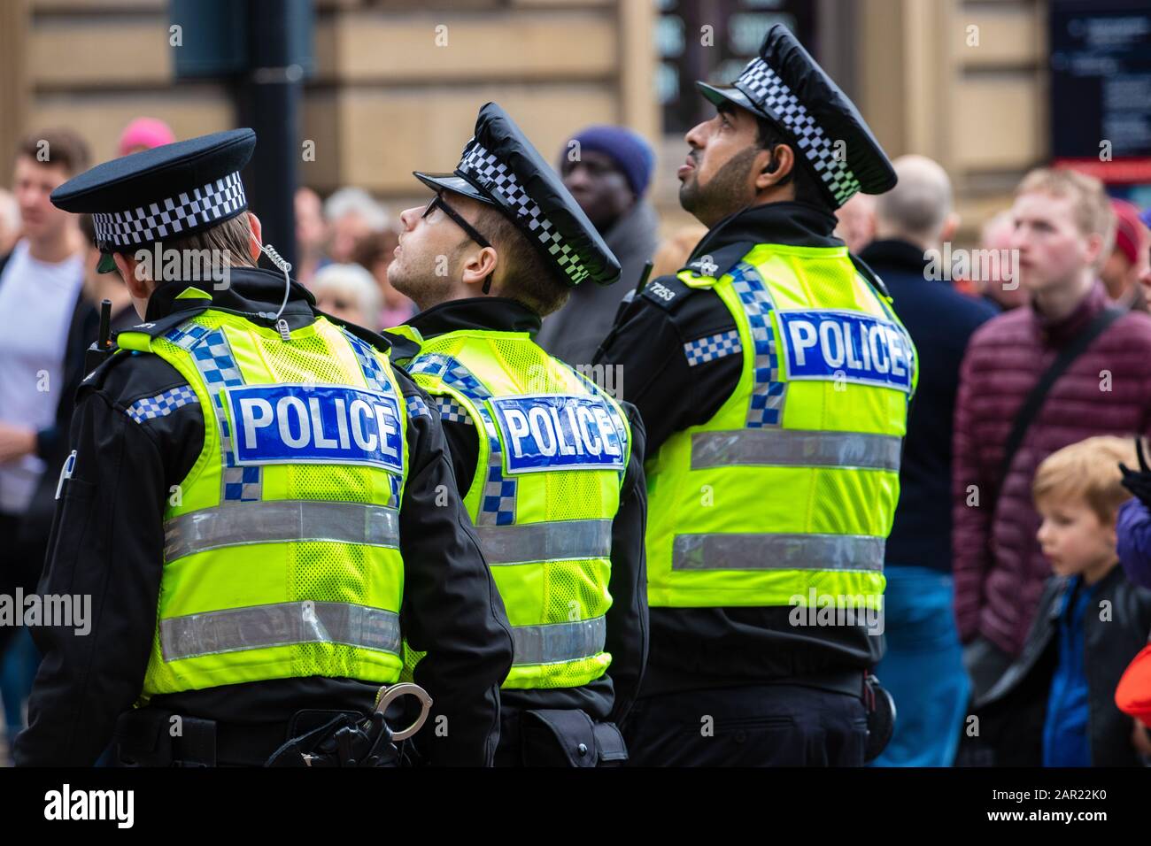 Leeds, ROYAUME-UNI - 05 mai 2019: 3 policiers en gilets jaunes regardant le grand écran à l'événement Tour de yorkshire dans le centre-ville de leeds Banque D'Images