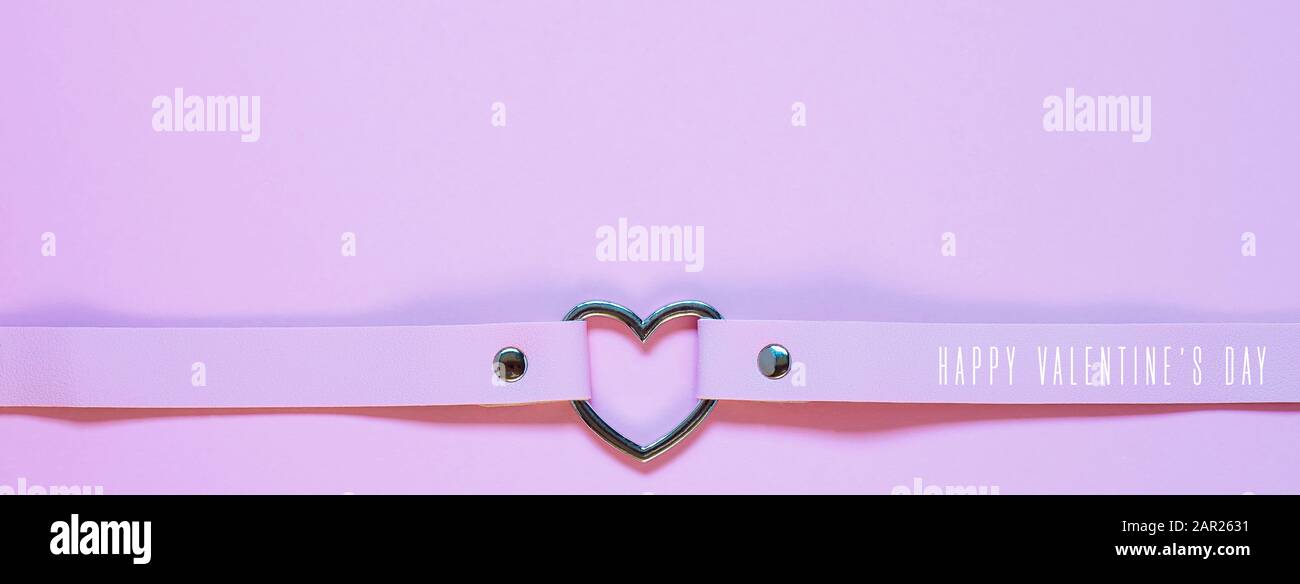 Chancre en cuir rose avec coeur en métal. Concept Saint Valentin Banque D'Images