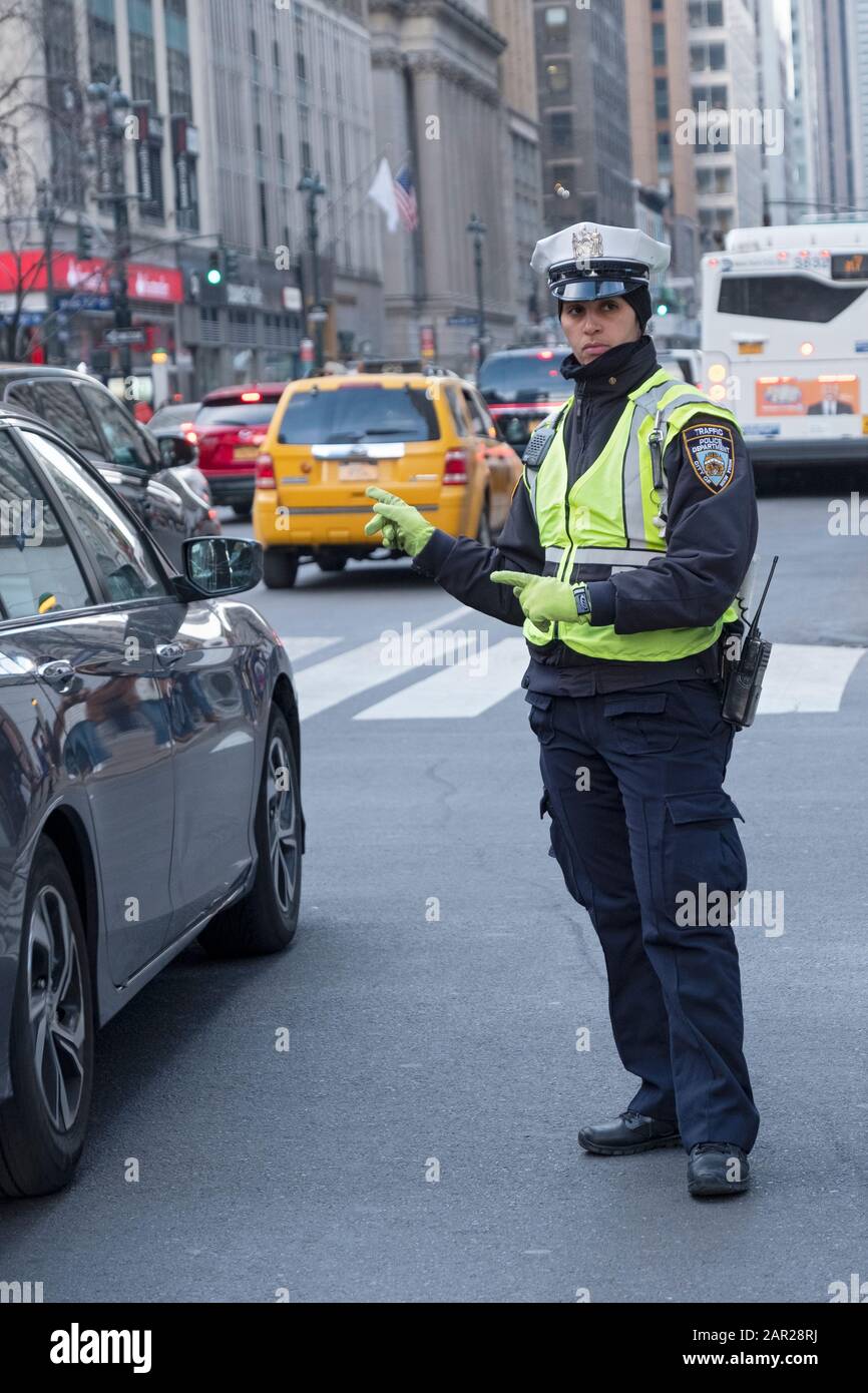 un flic de trafic New-yorkais dirige des voitures sur la 6ème Avenue & 34ème Street dans la section Herald Square de Manhattan, New York City. Banque D'Images