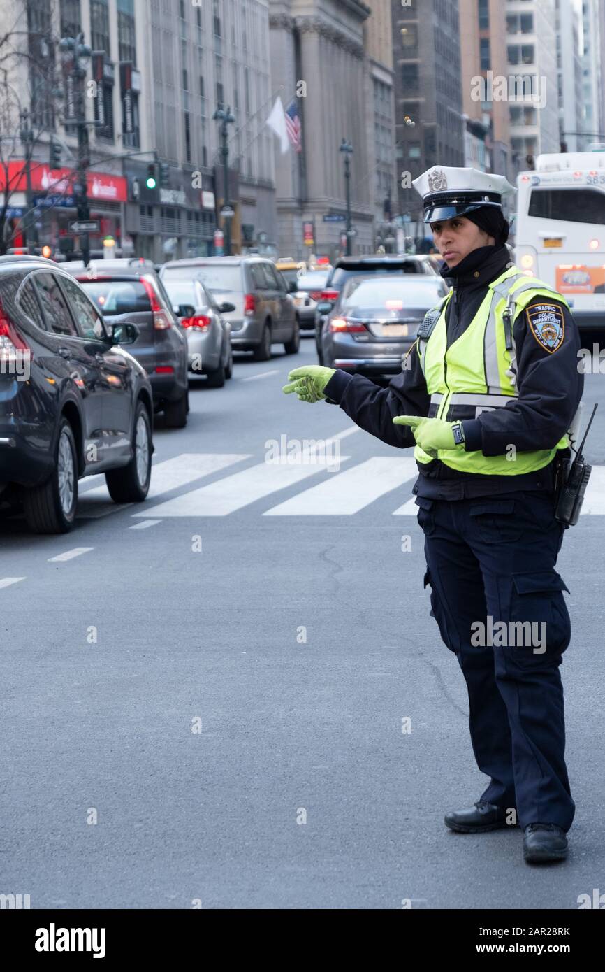 un flic de trafic New-yorkais dirige des voitures sur la 6ème Avenue & 34ème Street dans la section Herald Square de Manhattan, New York City. Banque D'Images