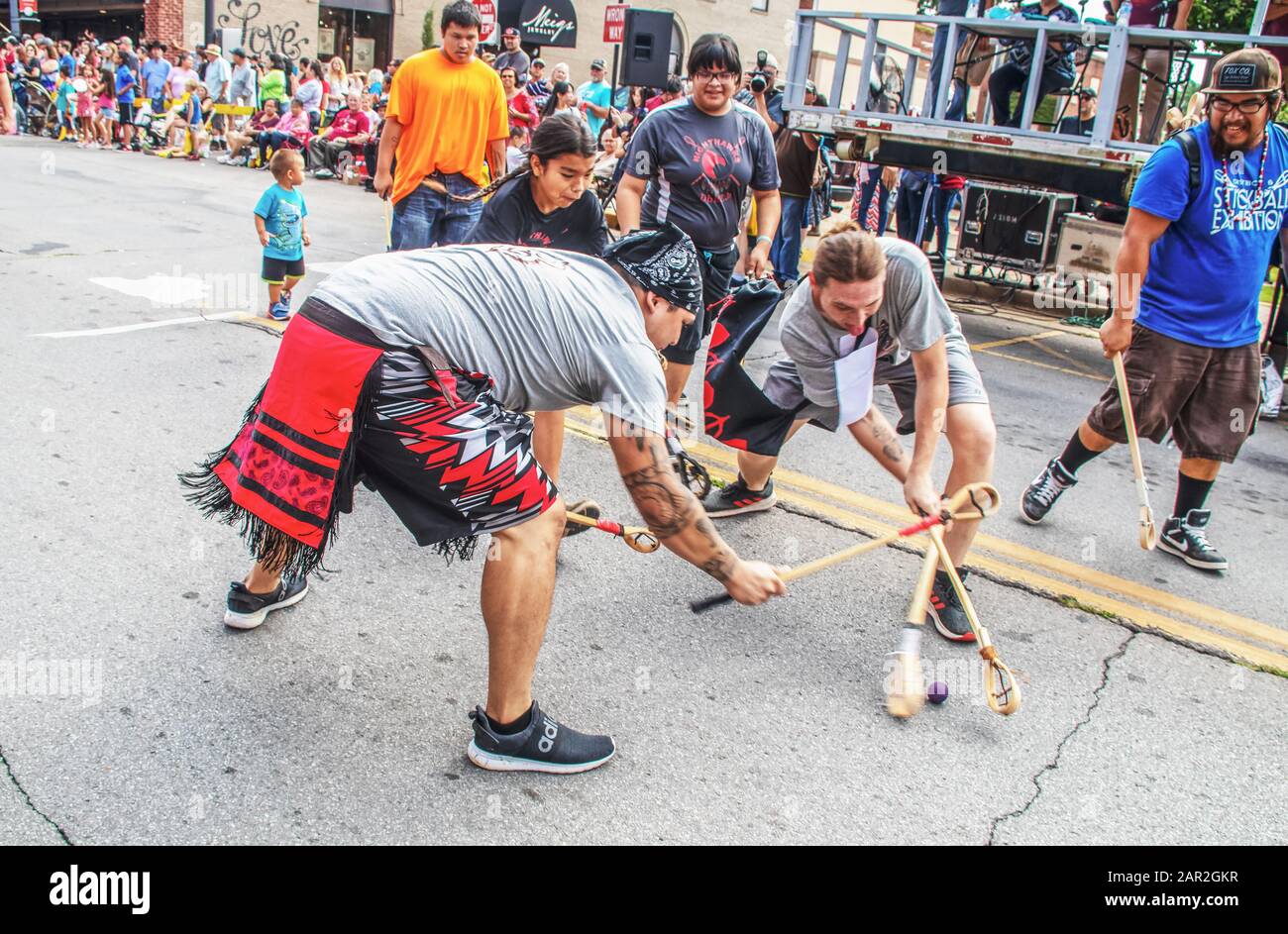 3-31-2018 Tahlequah USA - jeunes hommes amérindiens jouant au jeu d'exposition de la traditionnelle balle dans le milieu de la rue pendant le défilé - drôle Banque D'Images