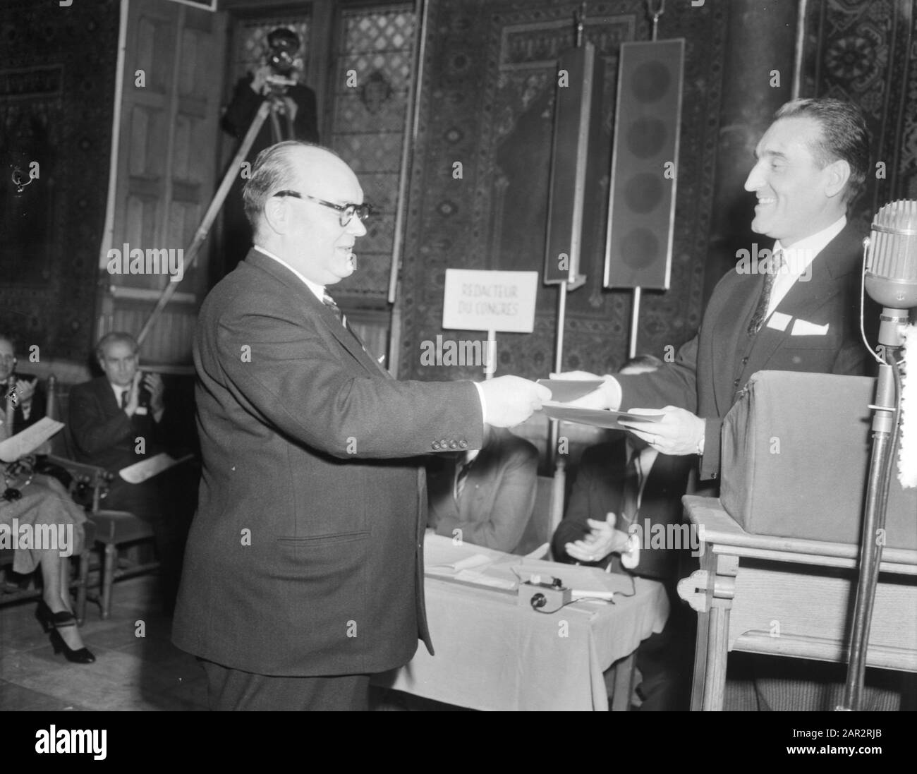 Le Mouvement européen du Congrès dans la salle des Chevaliers Paul Henri Spaak reçoit le premier passeport européen délivré par la Haute Autorité de la Communauté européenne du charbon et de l'acier Annotation: En fait, il n'avait pas droit à ce passeport parce qu'il n'était pas un fonctionnaire de la CECA, mais un président du Parlement. Mais pour lui une exception a été faite. Date: 8 octobre 1953 lieu: La Haye mots clés: Congrès, organisations internationales, passeports Nom personnel: Spaak, P.H. Nom de l'institution: Ridderzaal Banque D'Images
