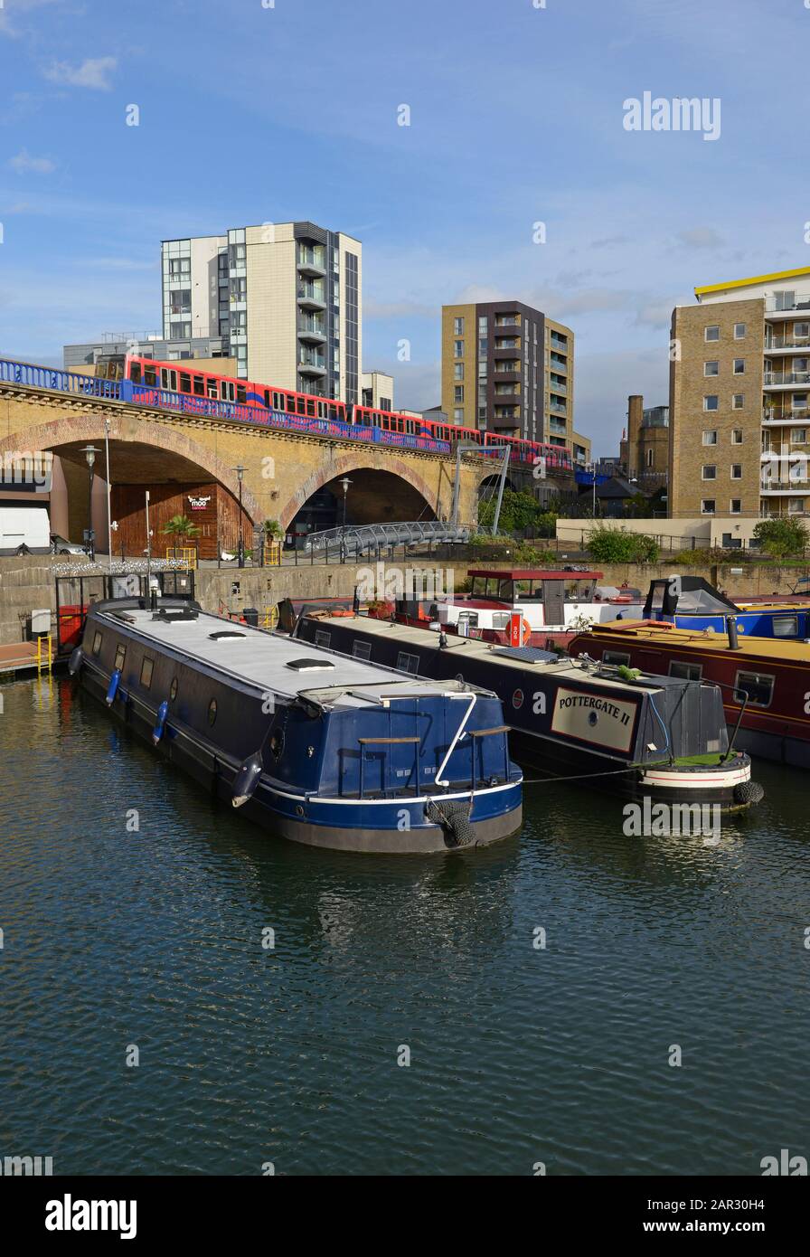 Un service de Docklands Light Railway passe par un viaduc à côté des bateaux résidentiels amarrés dans la marina de Limehouse Basin, dans l'est de Londres, Londres, Royaume-Uni Banque D'Images