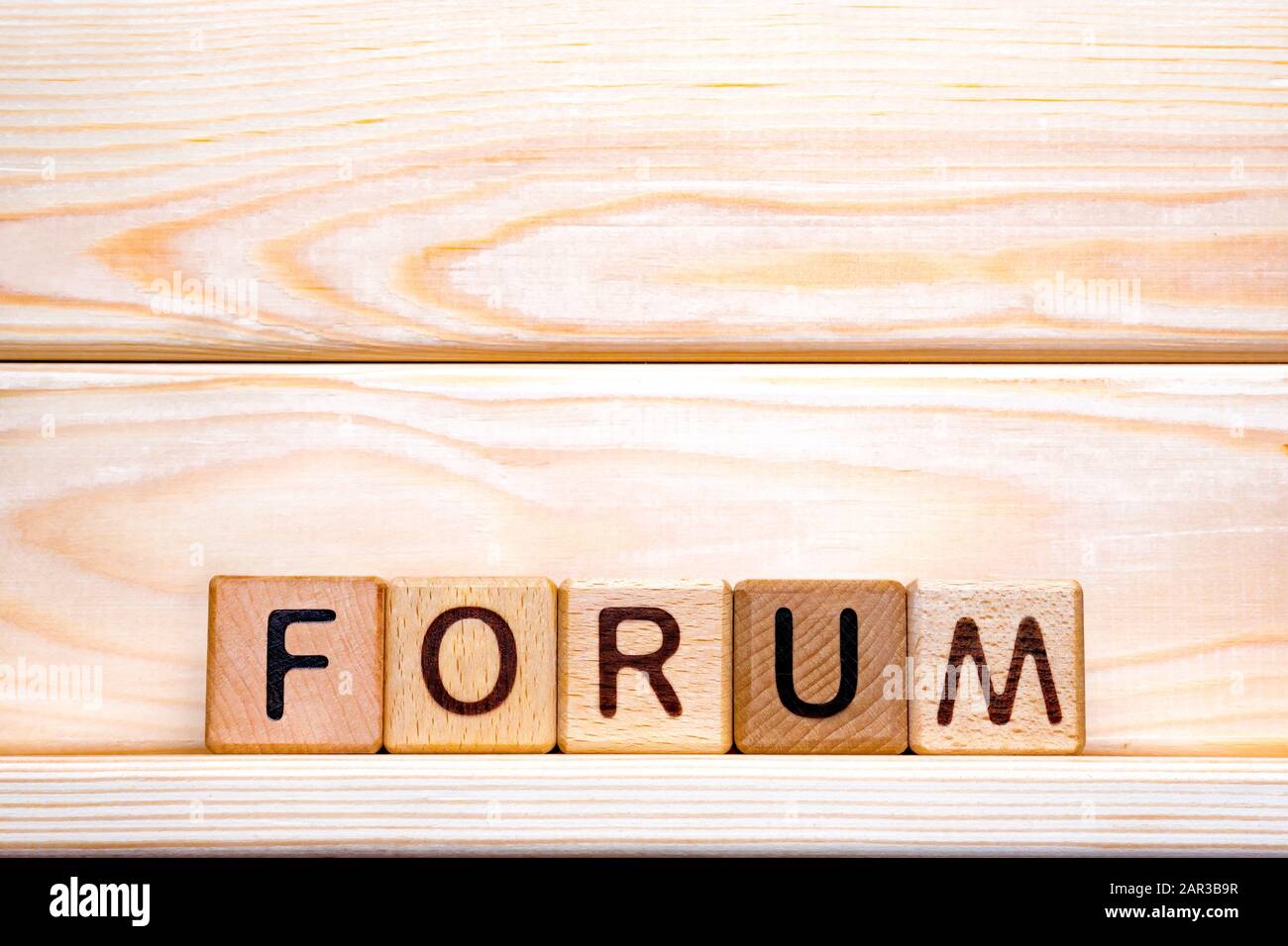 Mot de forum fait de bois d'arrière-plan. Concept d'entreprise. Panneau de forum, examen, concept d'apprentissage. Concept de calendrier. Word forum écrit avec des cubes en bois. Contrôle de la qualité de l'éducation. Contexte du forum Banque D'Images