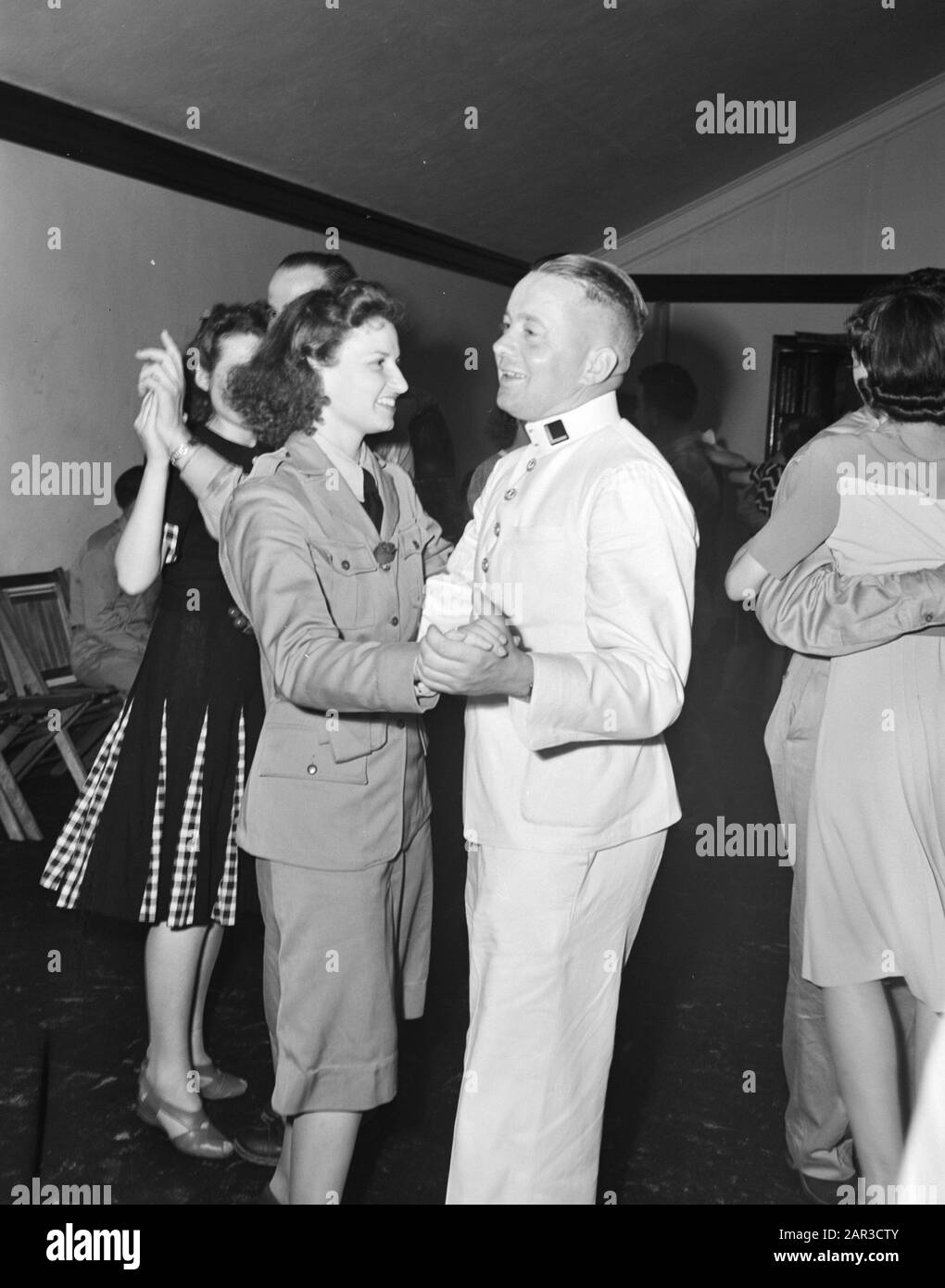 Royal Netherlands Military Flying School À Jackson, Mississippi. Les pilotes DU ML-KNIL, commandés par Le Général Majeur L.H. van Oyen, qui s'est échappé des Antilles néerlandaises de l'est, sont formés à fort Jackson, Mississippi. Flyer du Marine Aviation Service danse dans une danse locale avec une fille de la défense civile américaine Annotation: Cela devait être Adriaan Manschot - né à Jaarsveld 1916, mort le 9 février 1945 dans une collision entre deux B25 Mitchells sur Tienen (Tirlemont), Belgique. Il était alors officier-Vlieger 2ème kl à l'escadron 320 de la RAF. Date : 1942 Lieu : Base Aérienne De Jackson Army, M Banque D'Images
