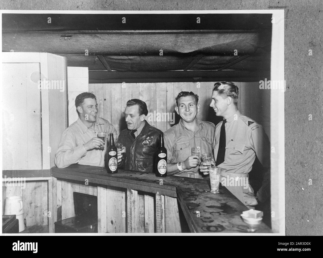 Recrues DE ML-KNIL (Armée indienne royale de l'aviation militaire) en formation au Camp St. Ives Bradfield Park près de Sydney (Nouvelle-Galles du Sud). Les deux instructeurs néerlandais qui ont été temporairement ajoutés au personnel en tant qu'interprètes profitent d'un verre de bière au bar de la sergeantsmess avec leurs collègues instructeurs. W/O Gatehouse, Sergent Zeelen, W/O Window, Sergent Willemse. Les deux sergents néerlandais étaient opérationnels dans le Nord comme des hommes armés Date: Juillet 1945 lieu: Australie, Sydney mots clés: Armée, militaire, formations, personnel de la seconde Guerre mondiale: Gatehouse, [...], Willemse, [...], Windon, [...], Zeelen, Banque D'Images