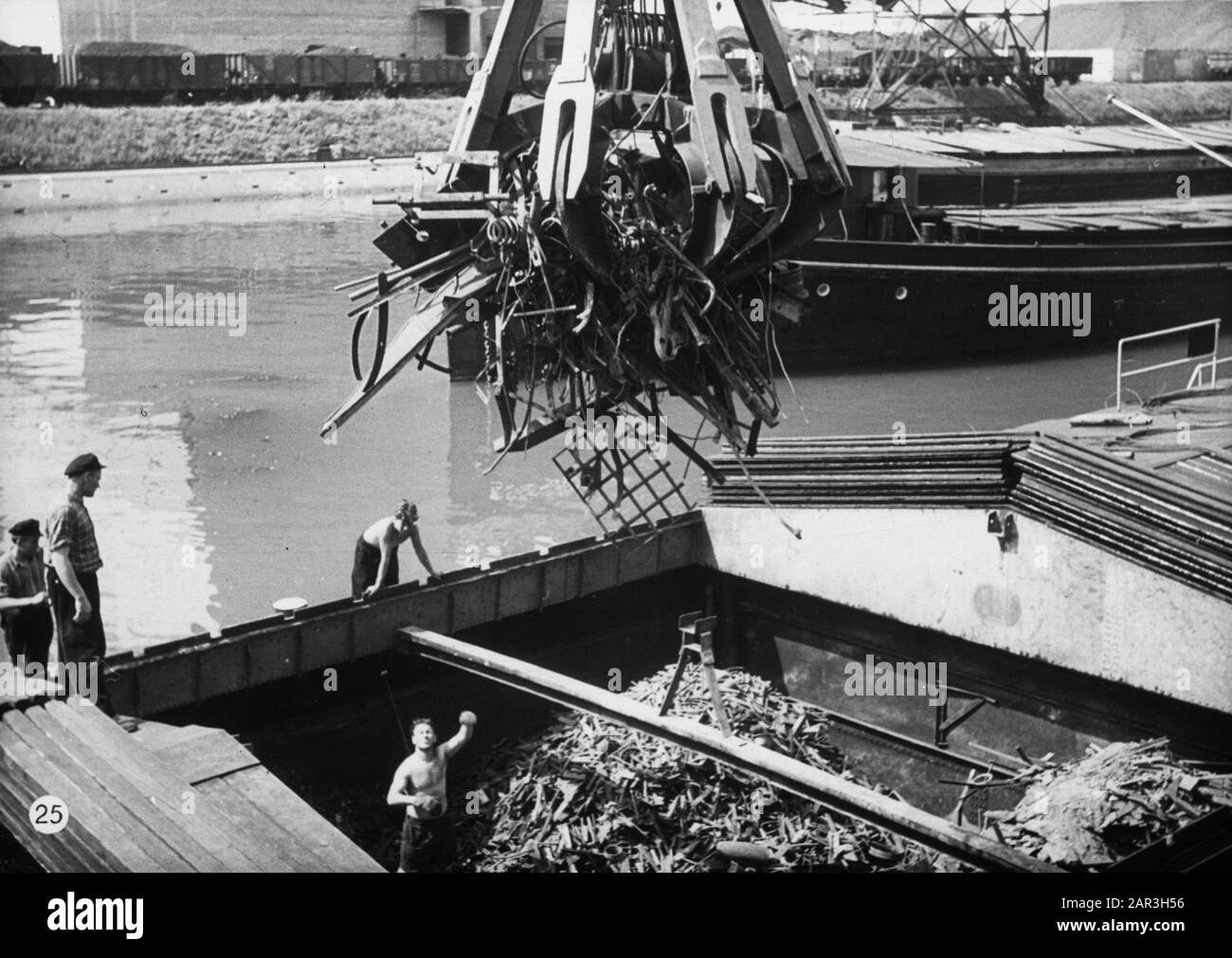 Gloire néerlandaise sur la navigation du Rhin, reportage du remorqueur Damco 9: Suisse. Déchargement de la ferraille dans le port de Bâle-Kleinhüningen Date: 1 avril 1955 lieu: Bâle, Suisse mots clés: Bateaux intérieurs, travailleurs portuaires, ports, grues, chargement et déchargement, débareurs, ferraille Banque D'Images