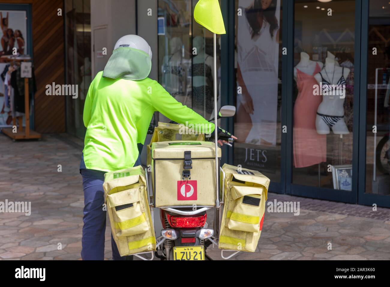 L'homme de poste australien livrant son vélo cyclomoteur honda à Lennox Head, Nouvelle-Galles du Sud, Australie Banque D'Images