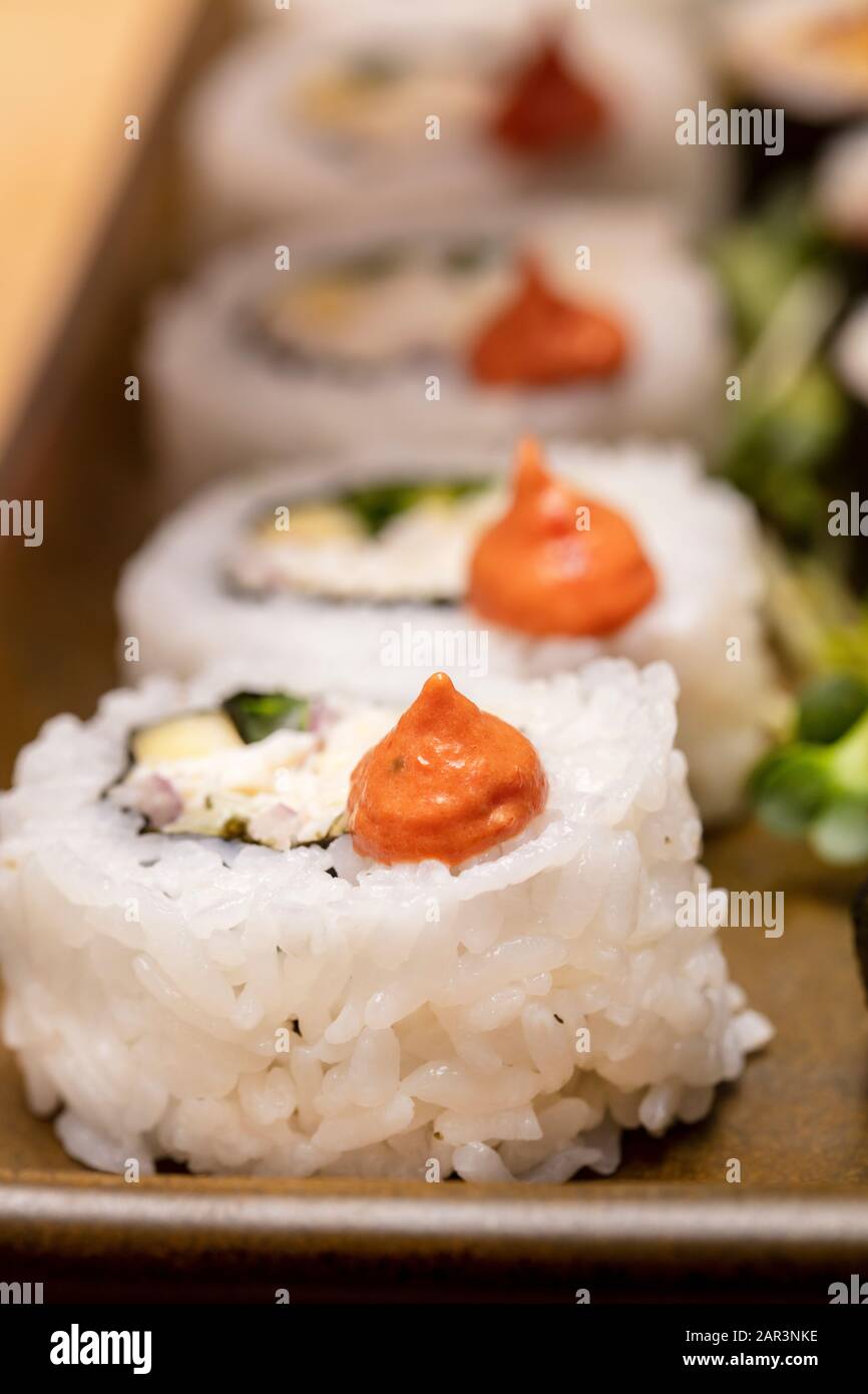 Couper les rouleaux de sushi trimed avec des fleurs et des racines de radis remplies de viande de crabe et de thon Banque D'Images