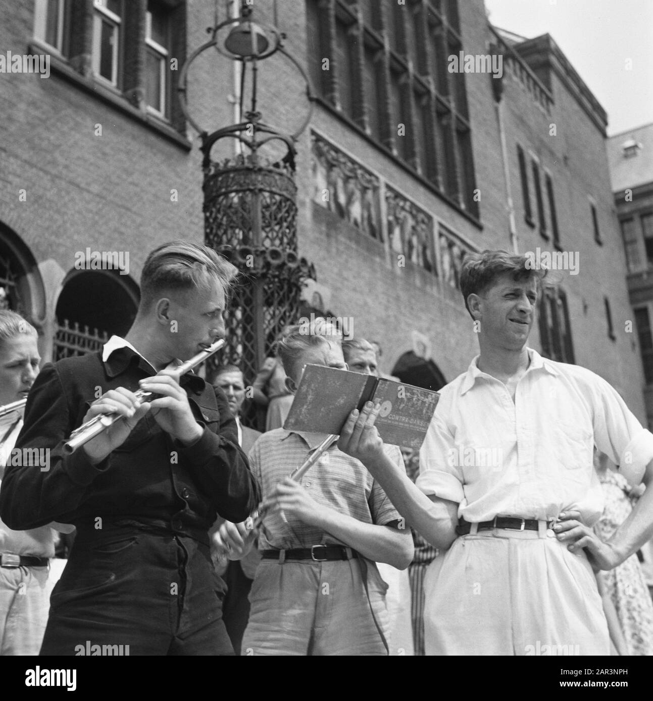 Les divertissements populaires à Amsterdam. Rép. Des diverses festivités après la libération dans la capitale [Flutistes aux Koopmansbeurs. Un homme conserve une brochure avec de la musique en feuilles] Date: Mai 1945 lieu: Amsterdam, Noord-Holland mots clés: Festivals de libération, seconde Guerre mondiale Banque D'Images