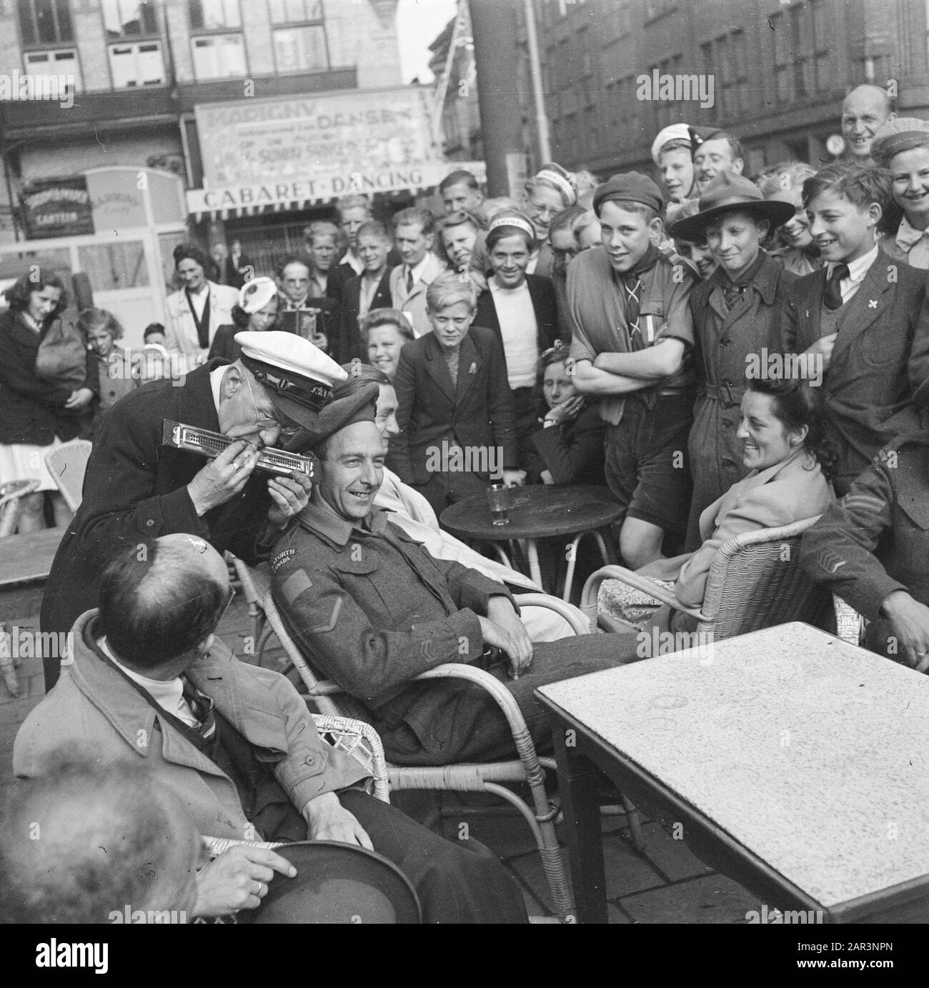 Les divertissements populaires à Amsterdam. Rép. Des diverses festivités après la libération dans la capitale [l'ancien homme joue de l'harmonica pour une annotation militaire canadienne: Lieu: Rembrandtplein? Date : 28 Juin 1945 Lieu : Amsterdam, Noord-Holland Mots Clés : Festivals De Libération, Seconde Guerre Mondiale Banque D'Images