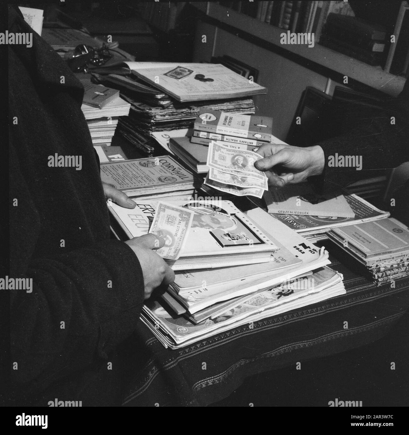 Finances: Purification de l'argent réductions de prix à la suite de la restructuration de l'argent. Librairie Annotation: Billets et livres en vente Date: 1945 mots clés: Finances, réductions de prix Banque D'Images