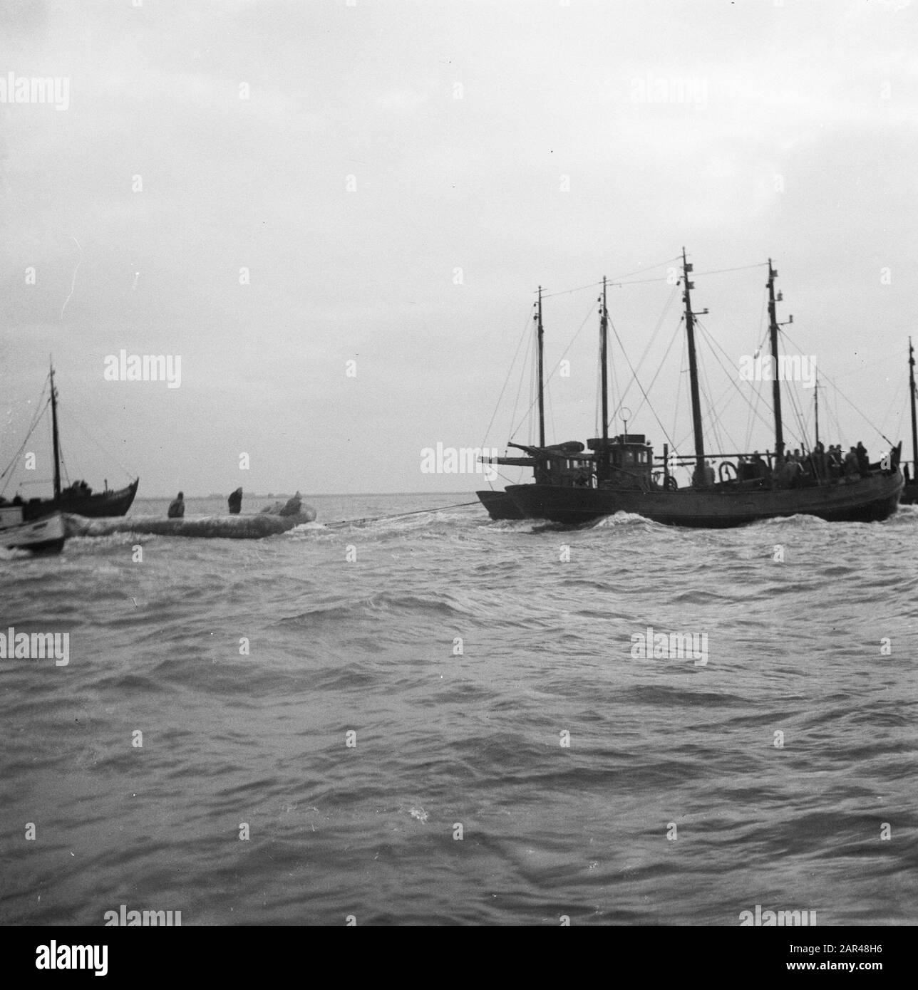 Watersnood 1953. Les botteurs de la Hollande du Nord sont arrivés dans les eaux de Zélande pour commencer leur travail de sauvetage. Seuls les botters avec bateau en caoutchouc dans le remorquage dans l'Hellegat, l'eau au nord de Overflakkee Date: 4 février 1953 lieu: Hellegat mots clés: Relief, inondations, navires Banque D'Images