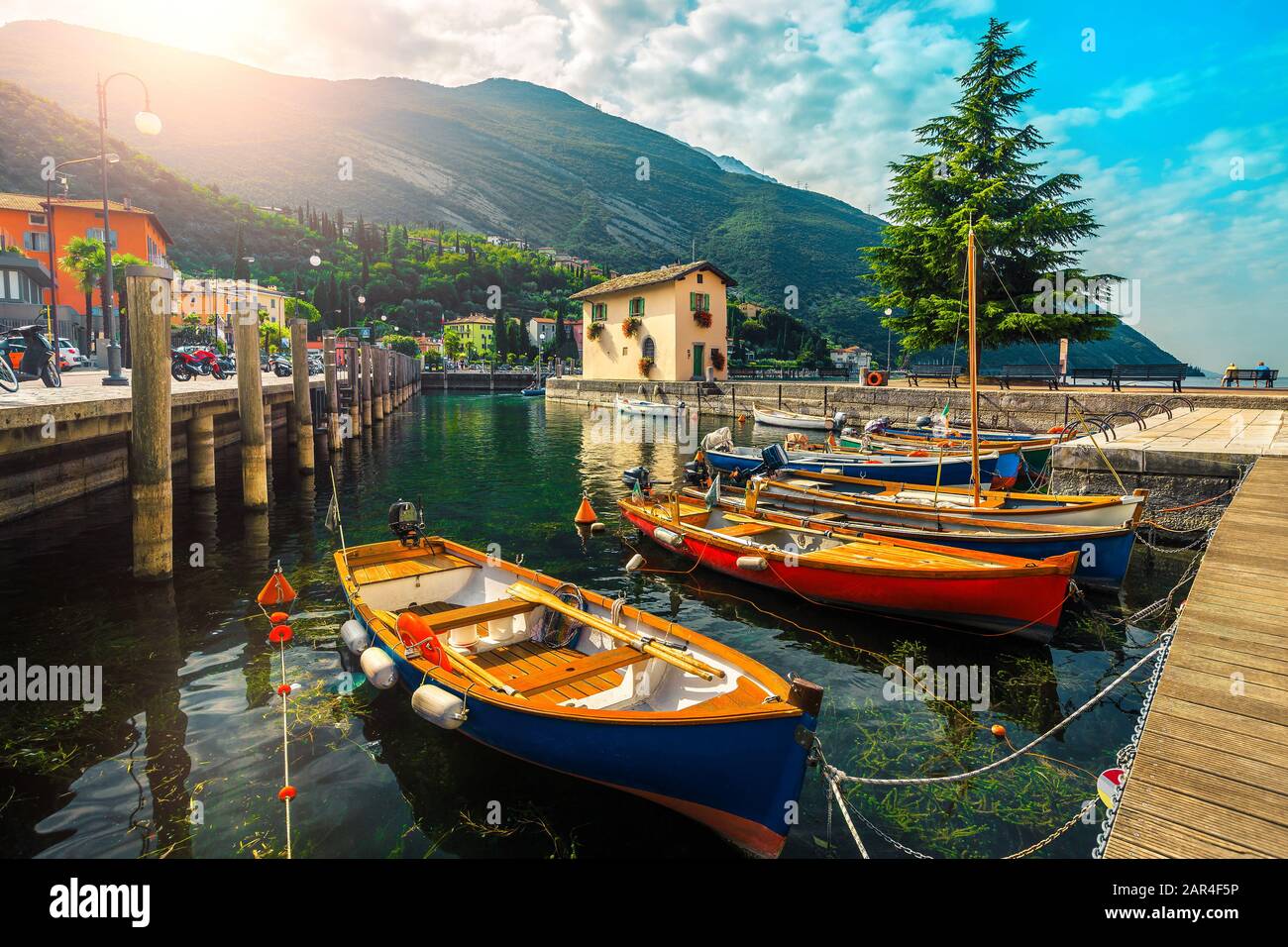 Spectaculaire bord de mer et port avec des bateaux en bois colorés ancrés sur le lac de Garde, Torbole Resort, Italie, Europe Banque D'Images