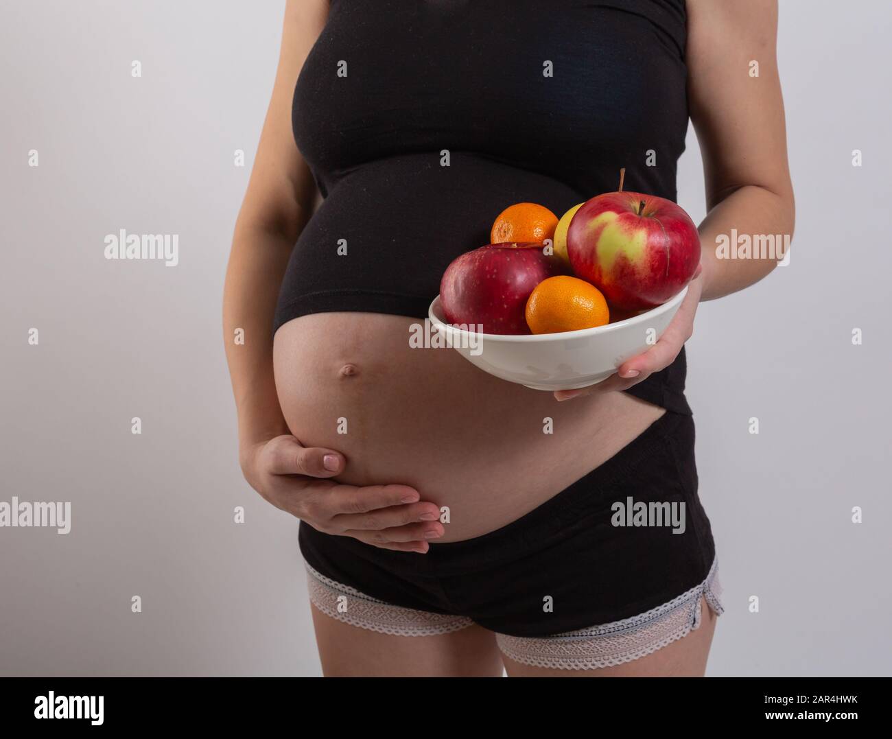 Grossesse et nutrition organique saine. La femme enceinte détient des fruits de vitamine frais, de l'espace libre. Placer pour le texte. Concept d'attente et de santé. Banque D'Images