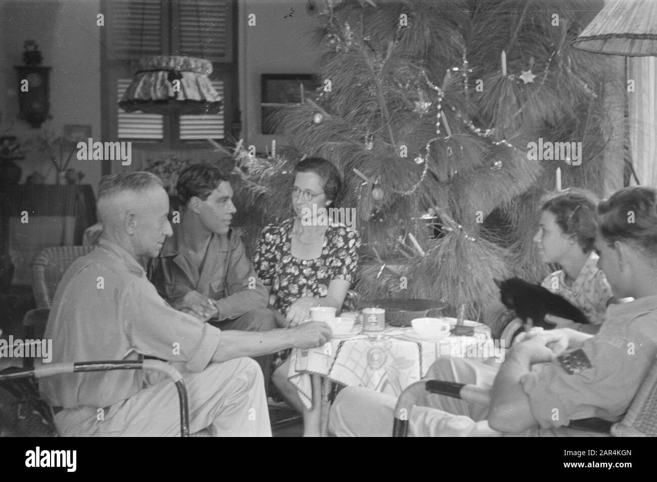 Fleurs pour la célébration des morts et de Noël à Semarang une compagnie autour d'une table près d'un arbre de Noël décoré Date: 25 décembre 1947 lieu: Indonésie, Pays-Bas Indes de l'est Banque D'Images