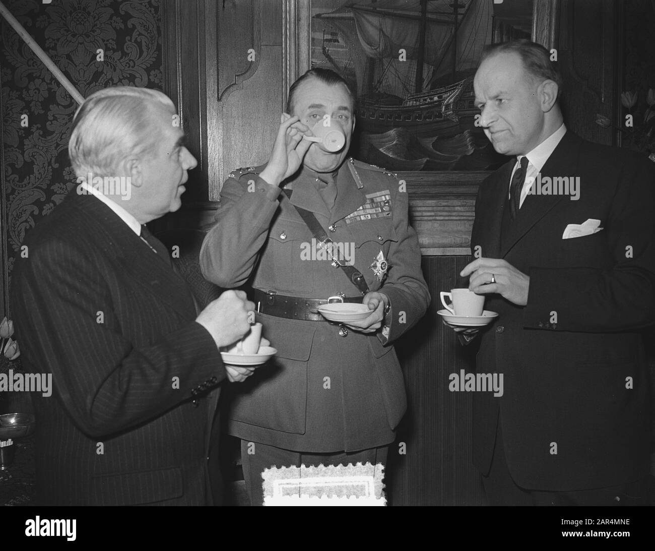 Le général Charles Foulkes, le libérateur canadien des Pays-Bas, s'est rendu à Wageningen où il a remis au maire M. J. Klaasesz le document de la capitulation. Après la livraison, une tasse de thé était ivre. À gauche l'ambassadeur du Canada Thomas A. Stone Date : 16 avril 1953 lieu : Gueldre, Wageningen mots clés : maires, diplomates, officiers militaires, thé, deuxième Guerre mondiale Nom personnel : Foulkes, Charles, Klaasesz, Jan, Stone, Thomas A. Banque D'Images