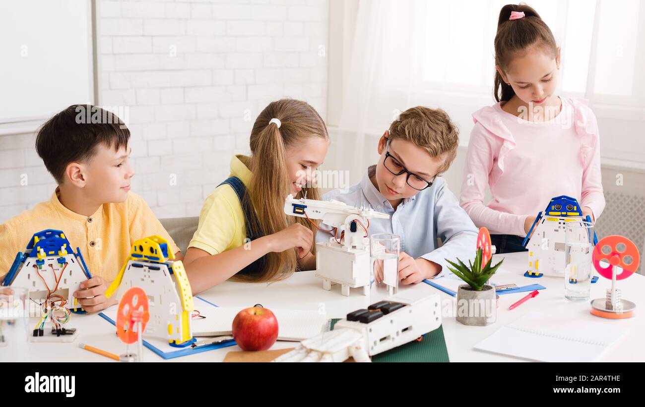 Enfants concentrés construisant des robots à la classe STEM Banque D'Images