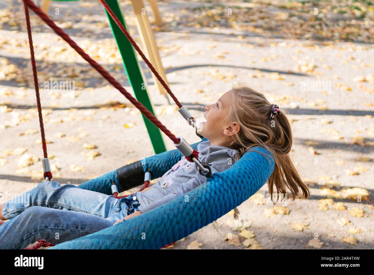 enfant balançant sur une balançoire Photo Stock - Alamy