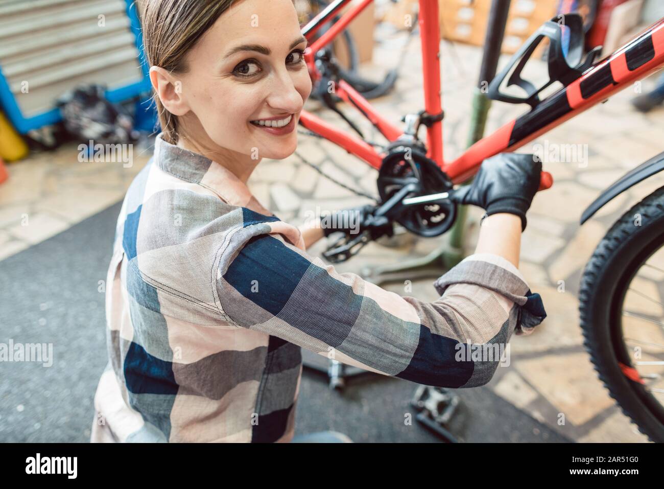 Heureuse femme travaillant comme mécanicien de vélo Banque D'Images