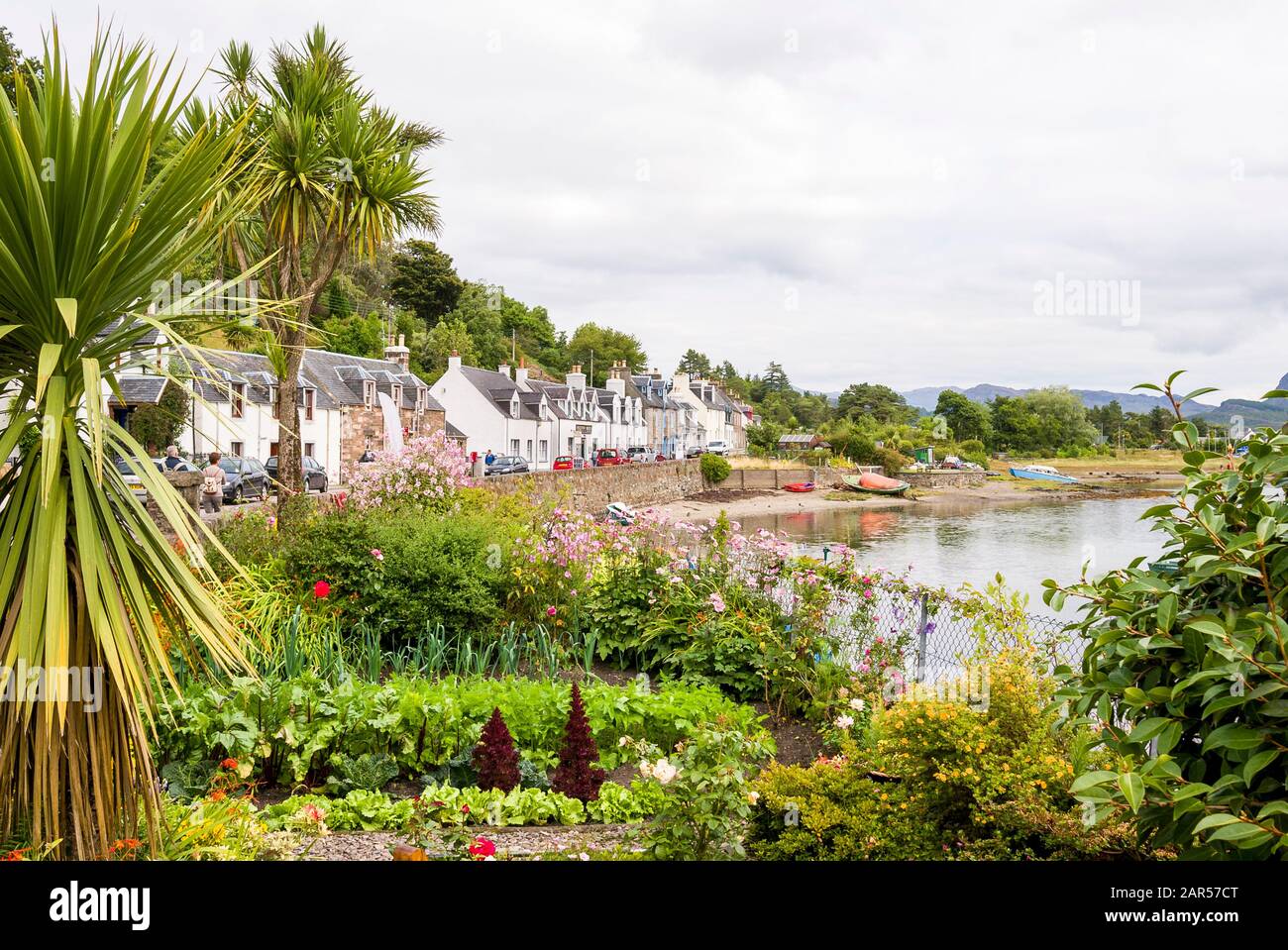 Vue panoramique sur un petit village écossais de Plockton sur la rive du Loch Carron montrant un petit jardin en pots au bord de l'eau, ra Banque D'Images