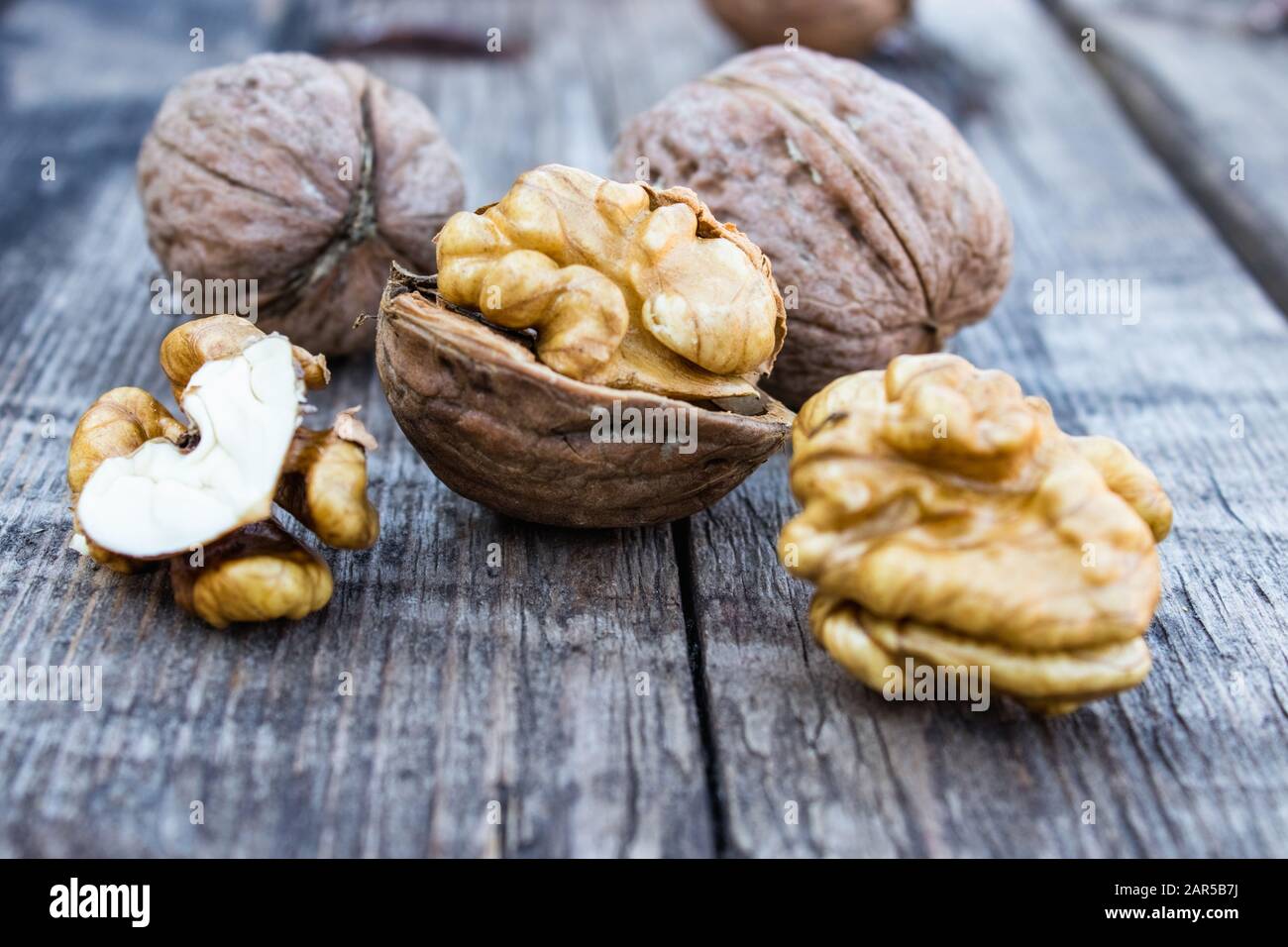 Les noix épluchées et les amandes de noyer se trouvent sur une vieille table rustique en bois. Récolter les noix. Banque D'Images