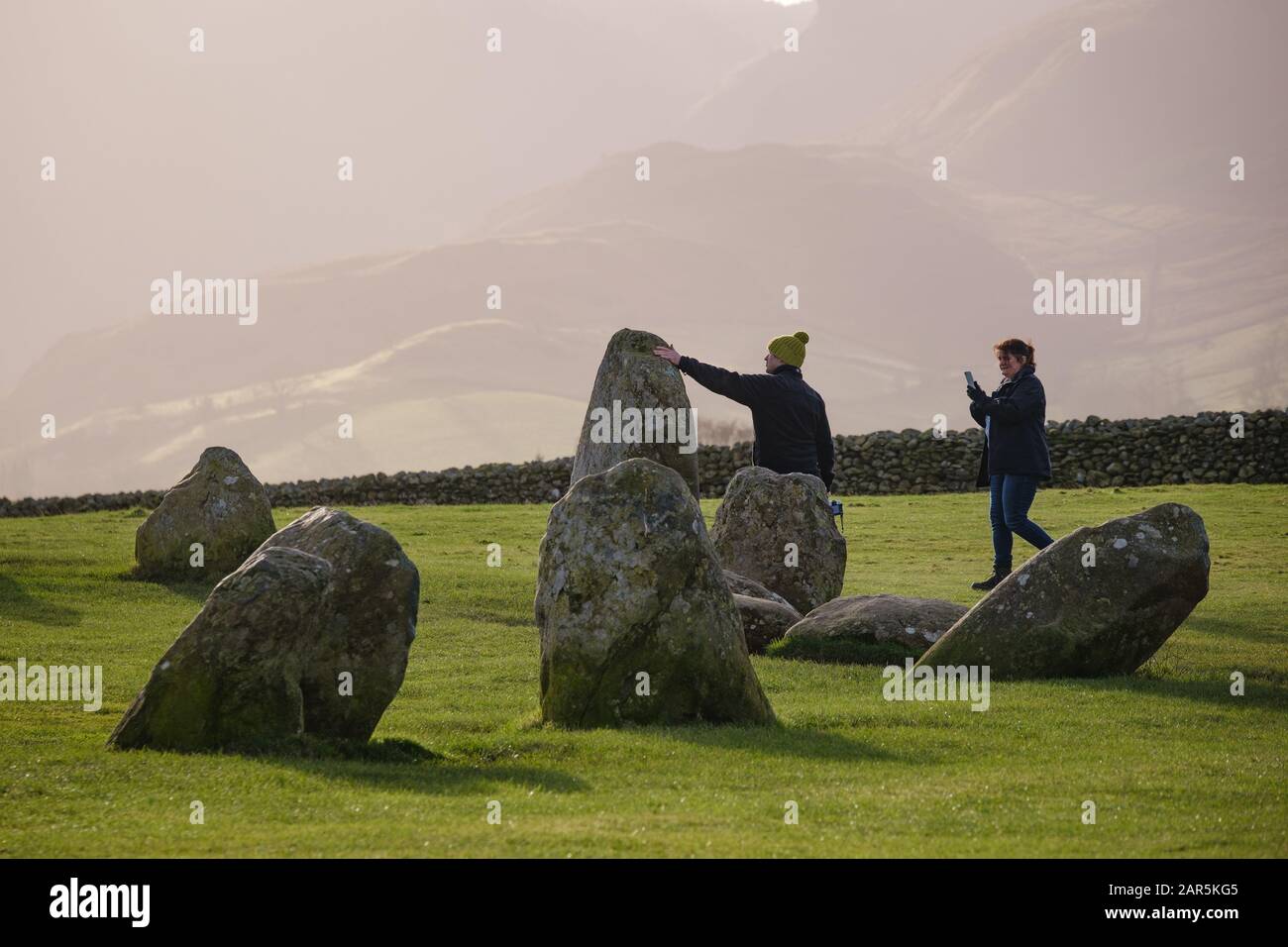 En touchant les pierres du cercle de pierre de Castlerigg dans le district du lac Banque D'Images