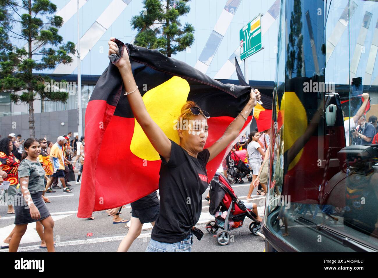 Manifestant avec un drapeau qui marchait dans les rues de Brisbane pendant  le rallye.les autochtones Yuggera et Turrbal ont organisé un rassemblement  connu sous le nom de Meanjin à une date synonyme