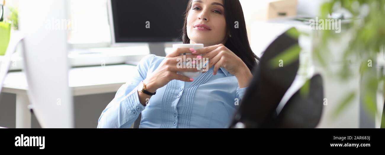 Pretty woman lying les jambes sur la table Banque D'Images
