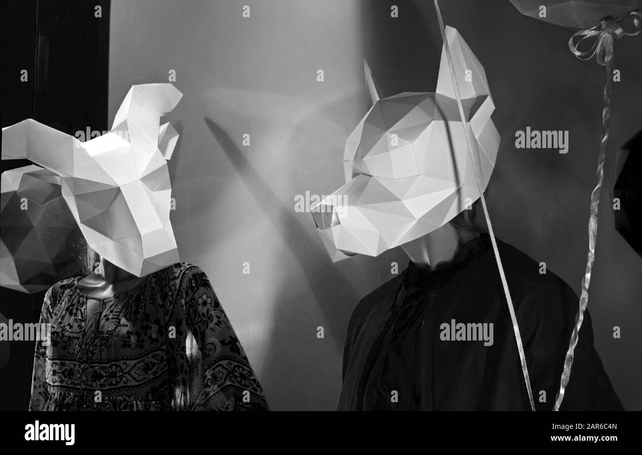 Mannequins avec masques en papier sous forme de chèvre et de loup. Décoration Storefront pour Halloween. Deux mannequins masqués se rapproquent. Banque D'Images