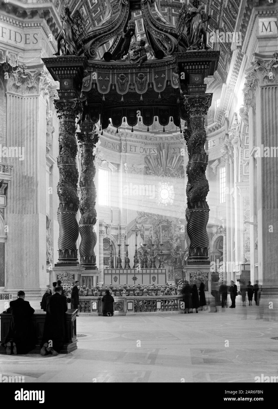 Rome: Visite au Vatican Les Gens et les pères priants dans les abis de la basilique Saint-Pierre au Baldachin de Bernini et en arrière-plan la Cathedra Petri Date: Décembre 1937 lieu: Italie, Rome, Cité du Vatican mots clés: Architecture, baroque, sculpture, intérieur, bâtiments de l'église Nom de l'institution: Saint Pierre Banque D'Images