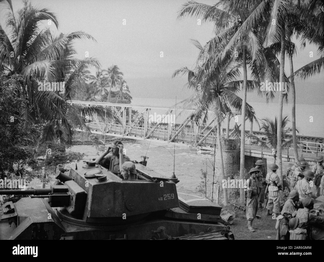 La marche des Soldats de Padang de la KNIL et du KL., qui ont été déposés par Catalina sur le lac Sikarang (Sumatra), a navigué dans des bateaux en caoutchouc jusqu'à un pont, afin de le faire occuper et de garder jusqu'à ce que les troupes arrivent par la route. Le pont peut être vu en arrière-plan. Annotation : au premier plan un réservoir des voitures blindées du 5ème escadron Date : 23 décembre 1948 lieu : Indonésie, Antilles orientales néerlandaises, Sikarang, Sumatra Banque D'Images